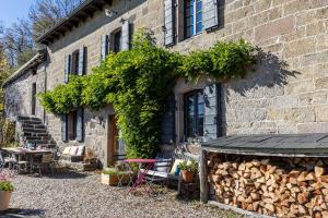 a brick house with a table and chairs and a building at Gîte le Clou in Thiézac