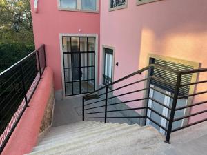 a pink building with stairs in front of it at Coração do Castelo AL in Castelo Branco
