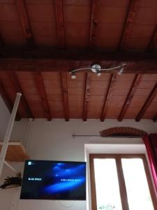 Pokój z sufitem, telewizorem i oknem w obiekcie Apartment ninnananna we Florencji