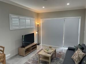 a living room with a couch and a flat screen tv at 2 bedrooms Entire Granny Flat in Werrington in Werrington