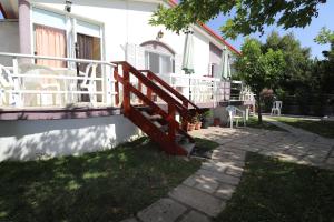 a house with a porch with white chairs on it at Ioannis House Apartment in Asprovalta