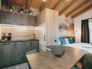 eine Küche und ein Schlafzimmer mit einem Bett und einem Tisch in der Unterkunft Studio Niederseer by we rent, JOKERCARD INCLUDED in Saalbach-Hinterglemm
