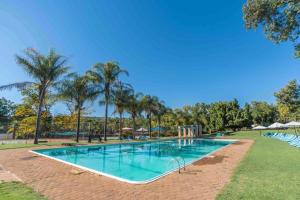 勒斯滕堡Sparkling Resorts and Spa的棕榈树公园内的游泳池