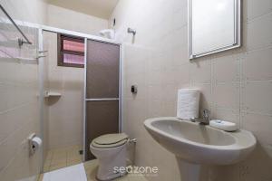 a bathroom with a sink and a toilet and a shower at Casa a 4 min a pé da praia em Porto Belo BRR0097 in Perequê +12 photos