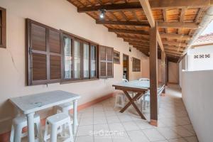 a room with a table and chairs and windows at Casa a 4 min a pé da praia em Porto Belo BRR0097 in Perequê