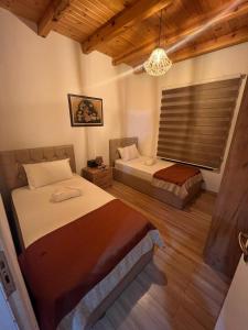 a bedroom with two beds and a chandelier at Saselisht Harmony 4 Bedroom Villa in Pogradec