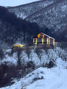a house in the snow with lights on it at Saselisht Harmony 4 Bedroom Villa in Pogradec