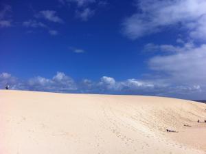 a sand dune on a beach with a blue sky at Casa La Pepita Las Lomas 117 in Caleta De Fuste