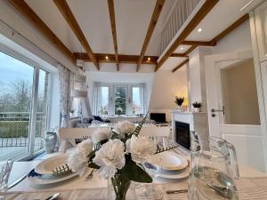 ein Esszimmer mit einem Tisch mit einer Vase mit Blumen in der Unterkunft FeWo Harleglück - Carolinensiel in Wittmund