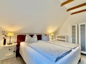 ein Schlafzimmer mit einem großen weißen Bett mit zwei Lampen in der Unterkunft FeWo Harleglück - Carolinensiel in Wittmund