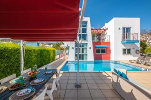 a villa with a swimming pool with a table and chairs at Villa Adaro - Large Luxury close to marina in Albufeira