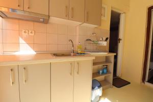 a kitchen with white cabinets and a sink at Ioannis House Apartment in Asprovalta +28 photos