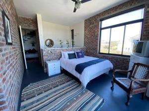 Un dormitorio con una cama y una pared de ladrillo. en Bella Capensis, en Yzerfontein 33 fotos más