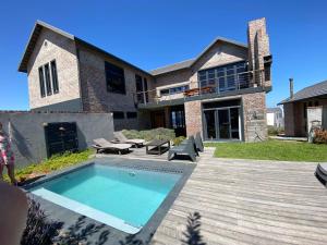 Un patio trasero con piscina y una casa. en Bella Capensis, en Yzerfontein