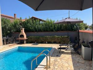 piscina con ombrellone e tavolo di Villa Lara 1 a Ližnjan (Lisignano)