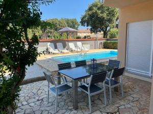 un patio con tavolo e sedie accanto alla piscina di Villa Lara 2 a Ližnjan (Lisignano)