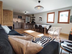 a living room with a couch and a table at Superbe Chalet Duplex 3* avec Parking et WIFI au Pied des Pistes, Valmorel - FR-1-356-392 in Valmorel +11 photos