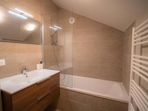 a bathroom with a tub and a sink and a shower at Superbe Chalet Duplex 3* avec Parking et WIFI au Pied des Pistes, Valmorel - FR-1-356-392 in Valmorel