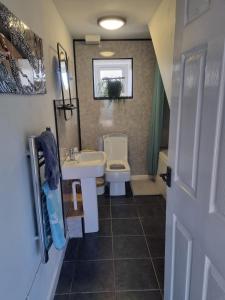 ein Badezimmer mit einem weißen Waschbecken und einer Toilette in der Unterkunft The Old Vestry - pet friendly! in Manortown