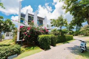ein Roller, der vor einem Haus mit Blumen parkt in der Unterkunft Villa 4pn Oceanami Resort Long Hải Phước Hải in Long Hải