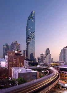 a city skyline with tall buildings and a freeway at Infinite Idol Home in Bangkok