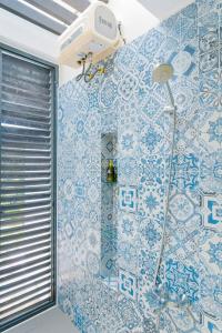 ein Badezimmer mit einer Dusche mit blauen und weißen Fliesen in der Unterkunft Villa 4pn Oceanami Resort Long Hải Phước Hải in Long Hải