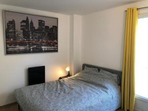 a bedroom with a bed and a picture of a city at Studio with terrace in Saint-Denis