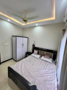 a bedroom with a large bed with two pink pillows at Home Abroad Guest House in Thathāl