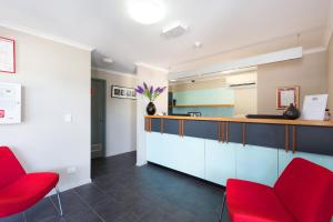 a kitchen with red chairs and a counter at Rocklea International Motel in Brisbane