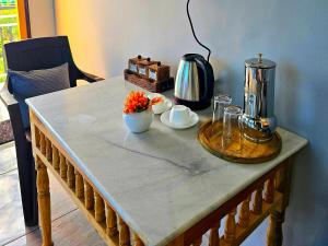 a table with a coffee maker and flowers on it at Mysuru Villa in Bīr