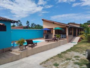 a house with a swimming pool and a patio at Pousada Baía do Sol Saquarema in Saquarema