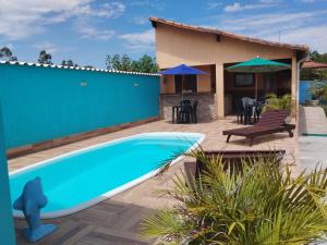 a villa with a swimming pool and a house at Pousada Baía do Sol Saquarema in Saquarema