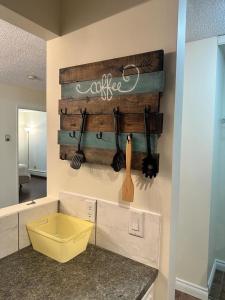 una cocina con una pared de madera y utensilios. en Cozy & bright private one-bed rm, en Edmonton