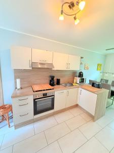 a kitchen with white cabinets and a stove top oven at Natur und Meer in Graal-Müritz +5 photos