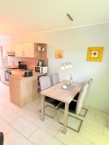 a kitchen with a wooden table and some chairs at Natur und Meer in Graal-Müritz