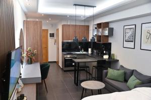 Una cocina y una sala de estar con un sofá y una mesa. en Efanton 2, en Larisa