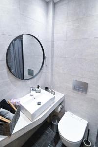 Un baño con un lavabo blanco y un espejo. en Efanton 2, en Larisa 43 fotos más