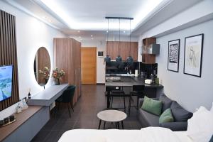 Una sala de estar con un sofá y una cocina. en Efanton 2, en Larisa