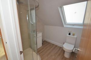 a bathroom with a toilet and a glass shower at Grove Lodge - A Somerset Retreat in Radstock +18 photos