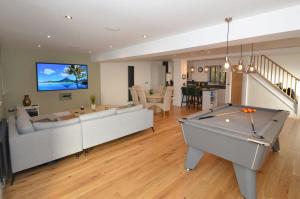a living room with a couch and a pool table at Grove Lodge - A Somerset Retreat in Radstock