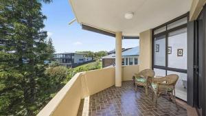 a balcony with a table and chairs and a view at Ocean Waves in Nambucca Heads +4 photos