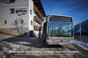 Autobus stoi obok budynku w obiekcie Ski In-Ski Out - Gästehäuser Saalbach-Hinterglemm - Wallegghof Christianhof w Saalbach Hinterglemm