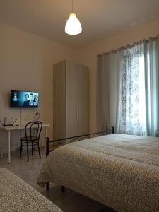 a bedroom with two beds and a table and a television at La casa di Lilly in Civitavecchia