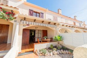 a villa with a courtyard in front of a house at Acogedora casa cerca de la playa in Torredembarra