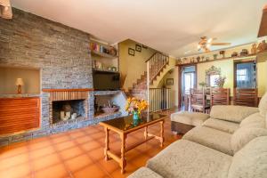 a living room with a brick wall and a fireplace at Acogedora casa cerca de la playa in Torredembarra