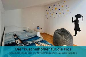 a bedroom with a bed with a lighthouse and stars on the wall at Appartement "Strandhöhle" - für die kleine Familie mit einem Kind in Binz