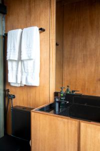 a bathroom with a sink and towels on a wall at Montefuego - Wellness Villa in Samaipata