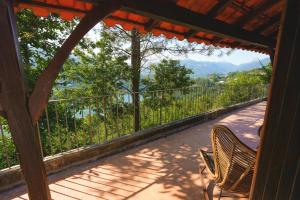 a porch with two chairs and a view of the mountains at Refúgio da Caniçada - T4, Piscina Aquecida (Gerês) in Geres