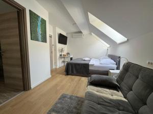 una camera da letto con un letto e un divano in una stanza di Gostisce Sovdat a Bovec