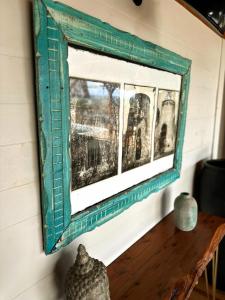 a mirror hanging on a wall next to a table at Villa Acoma Lodge in Grand-Bourg